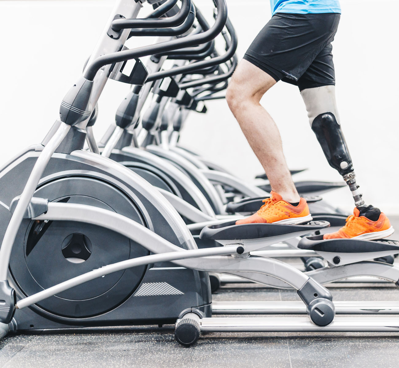 Disabled athlete with leg prosthesis training at the gym. Paraly